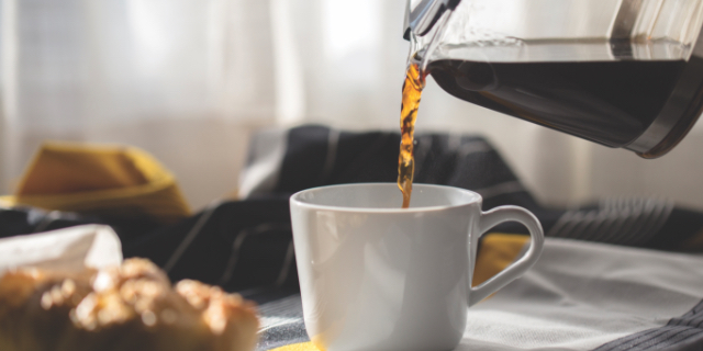 Coffee being poured into a white mug