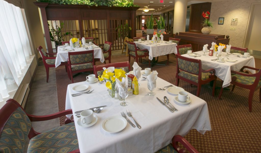 Dining room with white tablecloths and yellow dafodils on the tables