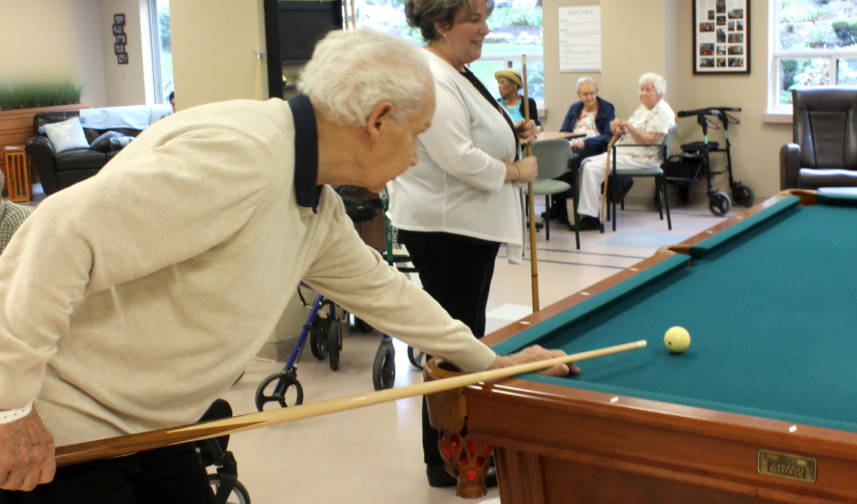 A senior man playing pool