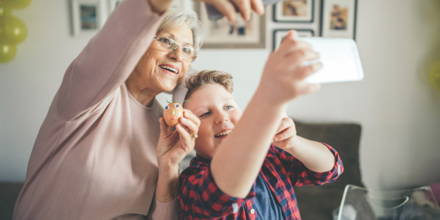 Grandmother and grandson taking a selfie photo with a mobile phone