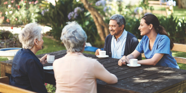 Group of people visiting at an outdoor table